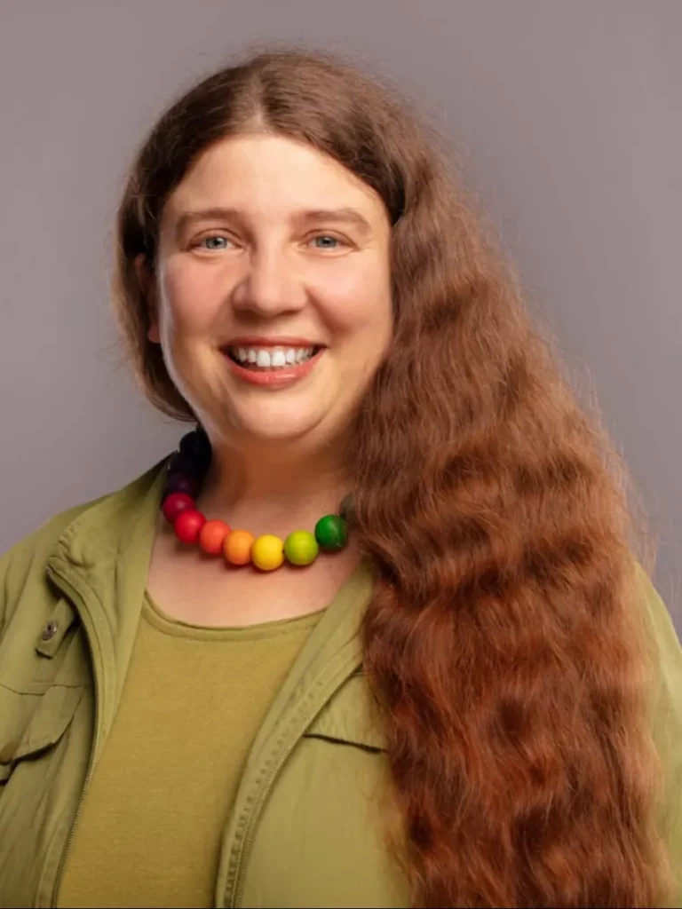 Das Bild zeigt ein Porträt von Sonja Manderbach, die freundlich in die Kamera lächelt.
